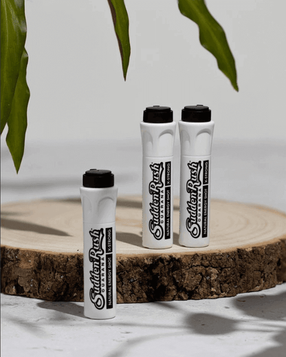 SuddenRush Extra Strong Black Guarana with Maca Energy Shot bottles on wooden surface with green leaves in the background